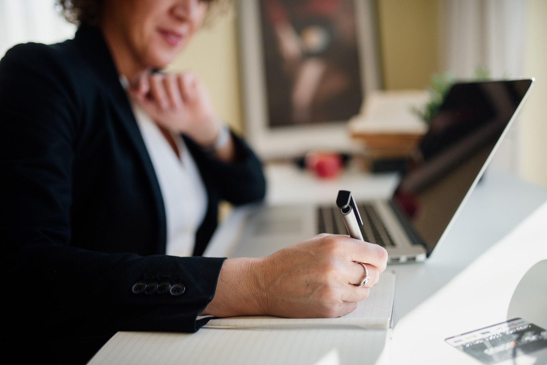 Advisor taking notes beside a laptop during a business review